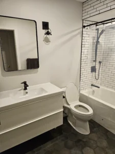 Raakss Reno white bathroom with floating vanity - neutral walls with tiles in the shower. Bathroom renovation in Aurora, small 3 piece bathroom